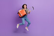 © deagreez - Full length portrait of overjoyed person jumping arms hold suitcase isolated on purple color background