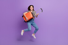 Full Length Portrait Of Overjoyed Person Jumping Arms Hold Suitcase Isolated On Purple Color Background