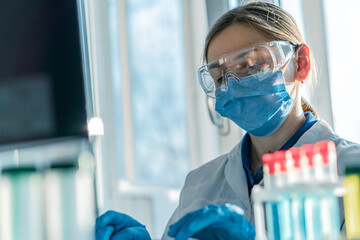 Poster - A medical scientist focuses on analyzing data on his computer to develop new drugs and therapeutic methods. A laboratory analyst is doing an experiment in a biotechnology laboratory and analyzing data