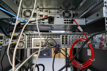 Fototapete - Rackmount chassis with installed server hardware in IT datacenter, rear view from power supply units. Selective focus.