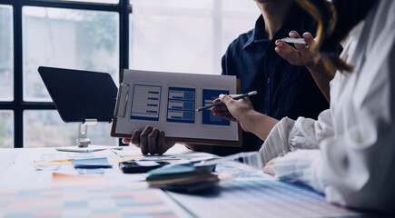Close up ux developer and ui designer brainstorming about mobile app interface wireframe design on table with customer breif and color code at modern office.Creative digital development agency