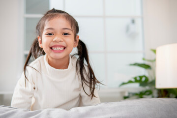 happy little asian girl child with a big smile and laughing healthy happy funny smiling face young a