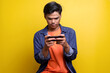 © Queenmoonlite Studio - Portrait of young man playing games on mobile phone with serious expression