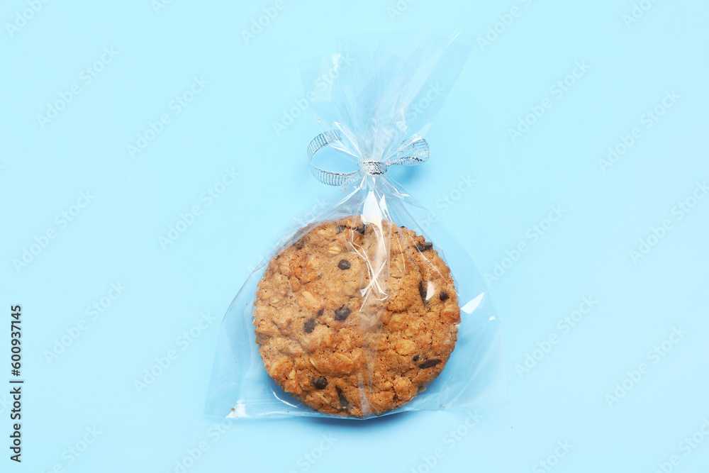 Tasty biscotti cookie in bag on blue background