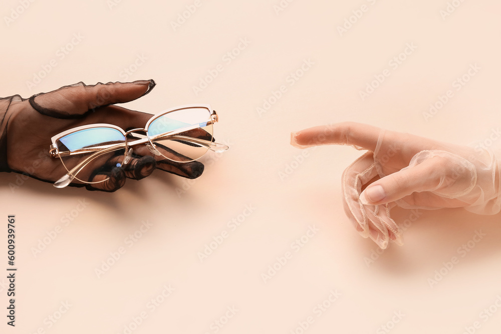 Women in laced gloves with eyeglasses on beige background