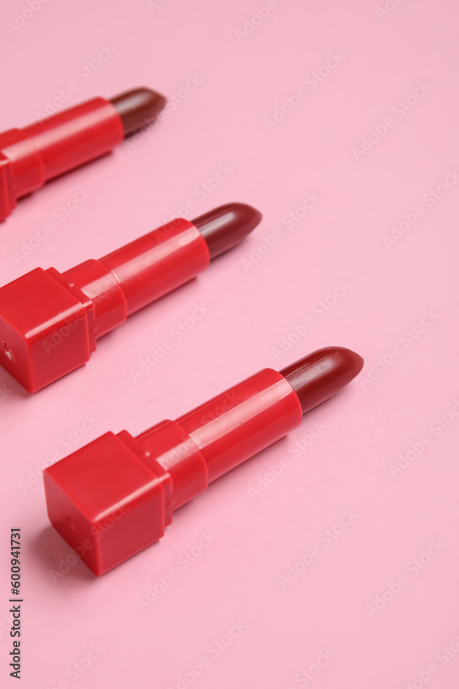 Red lipsticks on pink background, closeup