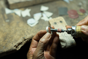 Close-up of craftsman hand making ring made of silver Folk handicrafts of Nan Province, Thailand	