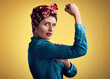 Woman, strong and flexing muscle portrait of a pinup girl in studio for beauty, power and fashion. Female person show bicep on a yellow background for motivation, freedom and retro or vintage style