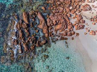 Wall Mural - Aerial top down view of rocky beach and clear blue water. Ocean waves on the beach as a background. Beautiful natural summer vacation holidays background. Western Australia. Coastal seascapes