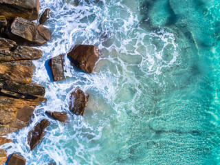 Wall Mural - Aerial top down view of rocky beach and clear blue water. Ocean waves on the beach as a background. Beautiful natural summer vacation holidays background. Western Australia. Coastal seascapes