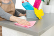 © Angelov - Attractive woman cleaning furniture in kitchen with a rag