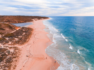 Wall Mural - Pink and orange sandy beach in Western Australia where the river meets the sea.