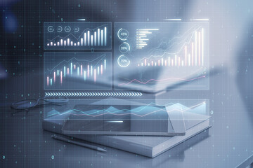 Aufkleber - Close up of tablet and book places on desktop with abstract glowing candlestick business chart on blurry background. Trade, finance, technology and market concept. Double exposure.