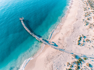 Wall Mural - Aerial top down view of Jetty and beach with crystal turquoise water. Beach as a wallpaper. Beautiful natural summer vacation holidays background. Jurien Bay, Western Australia. Coastal seascapes