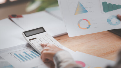 Fototapete - Businessman using a calculator to calculate numbers ,profit and loss statement review of company performance , cost analysis ,financial paperwork ,business account checking ,Annual budget planning