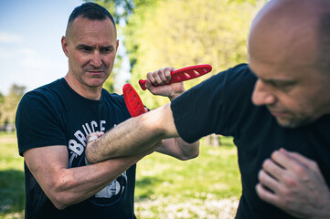 Wall Mural - Knife attack self-defense. Techniques of disarming knife attacker. Weapon disarm training