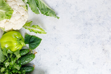 Wall Mural - Border of green raw vegetables on white background. Top view of healthy organic food. Copy space