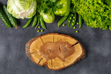 Wall Mural - Border of organic green raw vegetables on black table. Top view of healthy organic food. Copy space