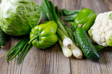 Wall Mural - Green raw vegetables on wooden background. Healthy organic food.