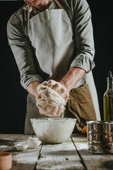 Wall Mural - Unrecognizable man in an apron kneading the dough