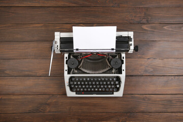 Fototapete - vintage typewriter on the table with blank paper on wooden desk - concept for writing, journalism, blogging