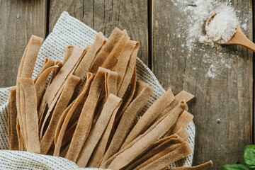 Wall Mural - Handmade raw pasta pappardelle from whole grain flour on rustic backhround