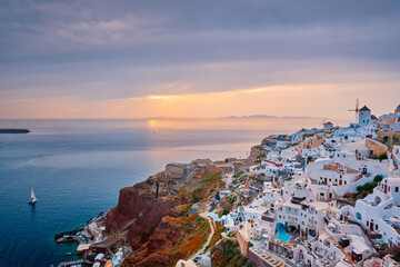 Wall Mural - Famous greek iconic selfie spot tourist destination Oia village with traditional white houses and windmills in Santorini island on sunset in twilight, Greece