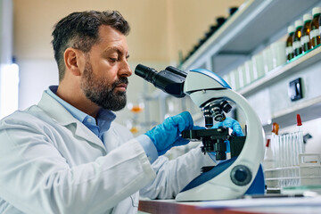Wall Mural - lab technician preparing medical sample for research under microscope.
