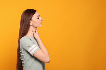 Poster - Young woman with sore throat on orange background