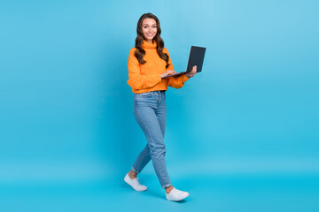Wall Mural - Full length photo of pretty cheerful woman wear orange sweater texting samsung apple gadget isolated blue color background