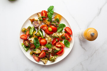 Top view of  summer tomato salad with green pesto and croutons