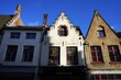 Schmale restaurierte Fassaden alter Häuser mit Treppengiebel vor blauem Himmel im Sonnenschein in der Altstadt von Brügge in Westflandern in Belgien