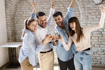 Group of happy business people toasting with wine at office party