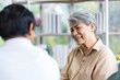 © SKW - Asian couple, elderly man and woman sitting on the sofa having fun chatting together at home. Concept: health insurance, life insurance, retirement happiness.