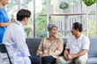 © SKW - Asian couple Elderly men and women sit on sofas having fun and having fun talking with doctors who come to check their health at home.