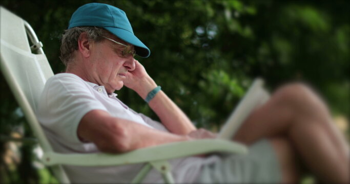 Casual older man reading book outdoors