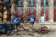 Blaue Verkehrszeichen im Sonnenschein vor einer alten Fassade aus Backstein mit alten Fenstern in den Gassen der Altstadt von Brügge in Westflandern in Belgien