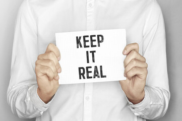 Poster - Man holding a paper card with text Keep it real