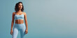 Attractive fit female model wearing sporty outfit on pastel blue background. Banner for fitness, lifestyle, sports.