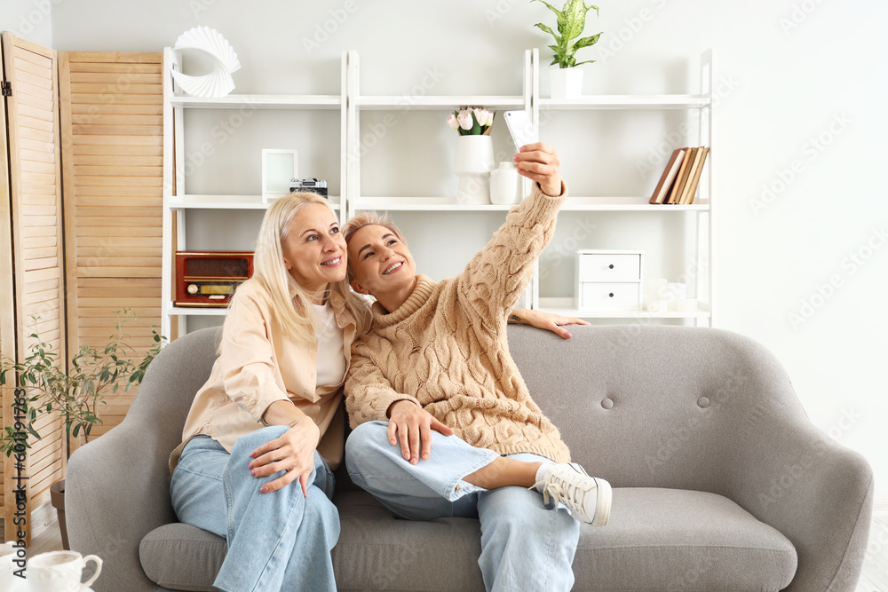 Happy mature women taking selfie at home