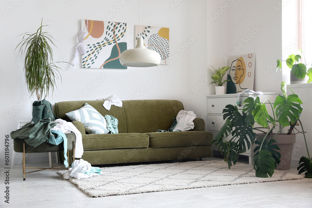 Interior of living room with sofa and dirty clothes