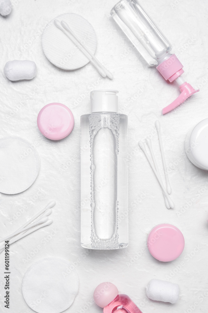 Micellar water with cotton buds and pads on white background