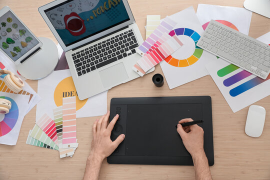 Designer using graphic tablet in office, top view
