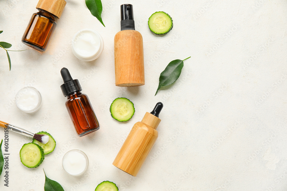 Composition with natural cosmetic products and cucumber on light background