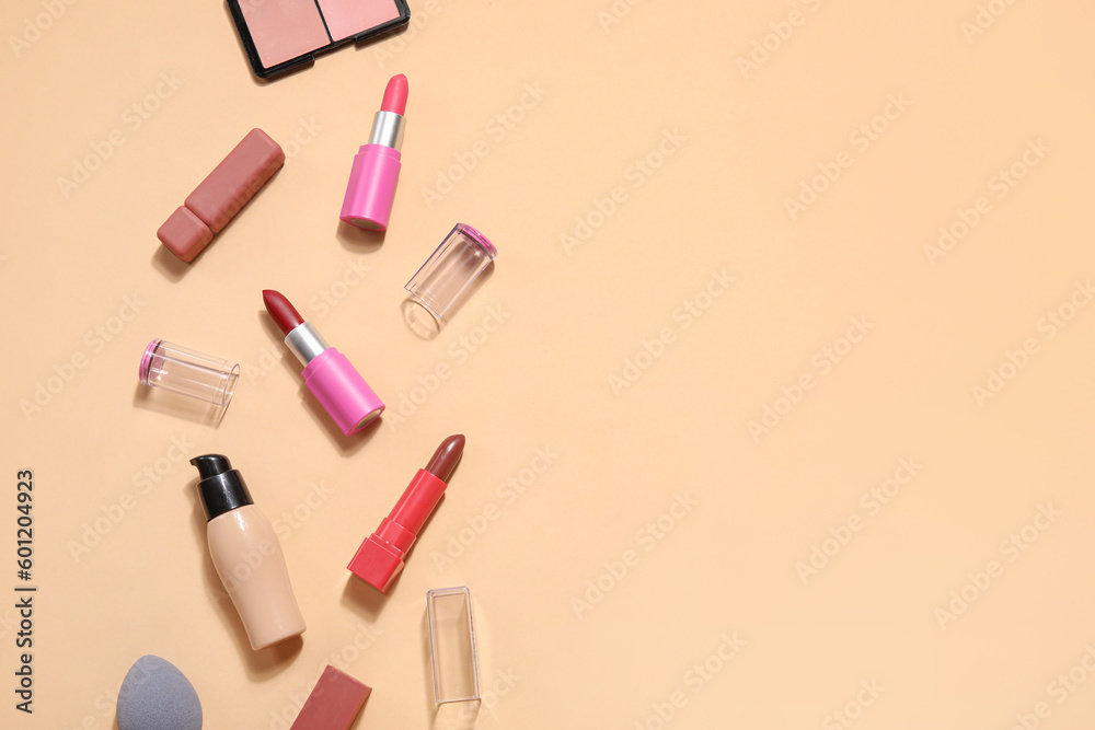 Decorative cosmetics with lipsticks on beige background