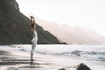 Wall Mural - Woman resting after yoga practice on the beach.