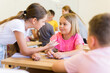 © JackF - Small school kids, girls and boys, sitting together and discussion project in groups at lesson in school