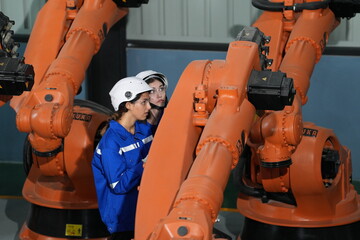 Poster - Robotics engineer working on maintenance of robotic arm in factory warehouse. Business technology.