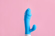 Vibrator with lubricant on pink background