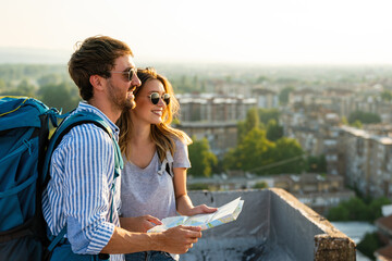 Wall Mural - Happy couple on vacation sightseeing city with map. People travel fun love concept.